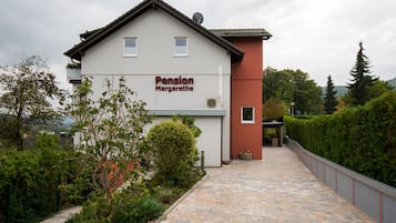 Ein Gebäude mit der Aufschrift "Pension Margarethe" und einem gepflasterten Weg, der zum Eingang führt.