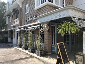 A brick building with a sign reading "Et Certa." - M. Swita - Adults Only (Bangkok)