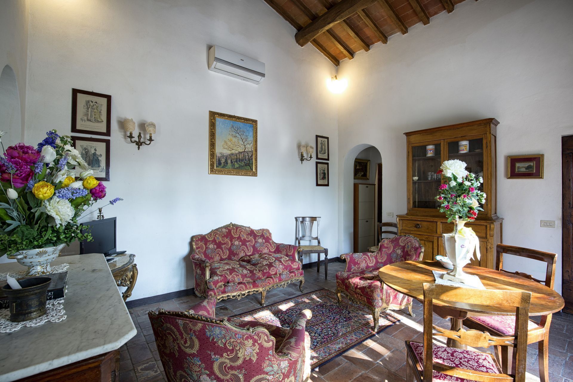 A traditional living room with a fireplace, a dining table, and a sofa set.