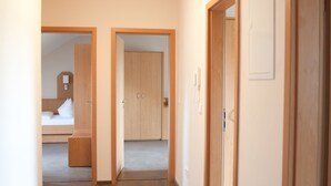 A hallway leading to a bedroom and a bathroom, with wooden doors and a light fixture on the ceiling. - Apartmenthaus Wesertor (Kassel)