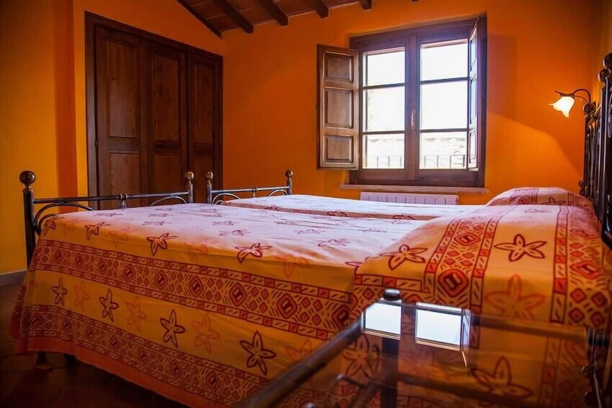 Une pièce avec un lit, une fenêtre et une porte.