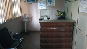 A reception area with a desk, a computer, a wall-mounted clock, and a calendar. - Abeokuta Hill View Hotel (Abeokuta)