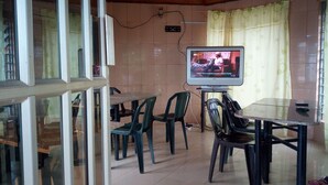 A dining area with a television, chairs, and a table. - Abeokuta Hill View Hotel (Abeokuta)