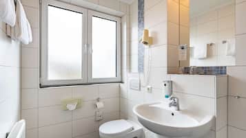 Et moderne badeværelse med toilet, vask og vindue.