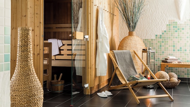 A wooden sauna room with a wooden bench, a large woven vase, and a tiled wall. - Dorint Parkhotel Siegen (Siegen)