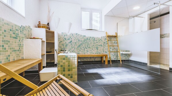 Un baño moderno con un banco de madera, un lavamanos, una escalera y una pared con azulejos.