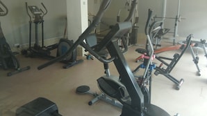 Ginásio com diversos equipamentos de exercício, incluindo esteiras, bicicletas ergométricas e aparelhos de musculação.
