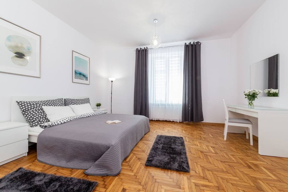 A modern bedroom with a bed, a desk, and a chair.