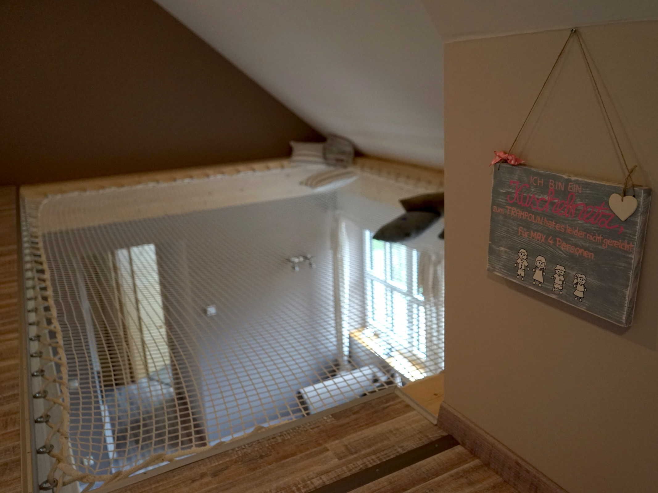 A room with a small window, a white ceiling, and a sign on the wall.