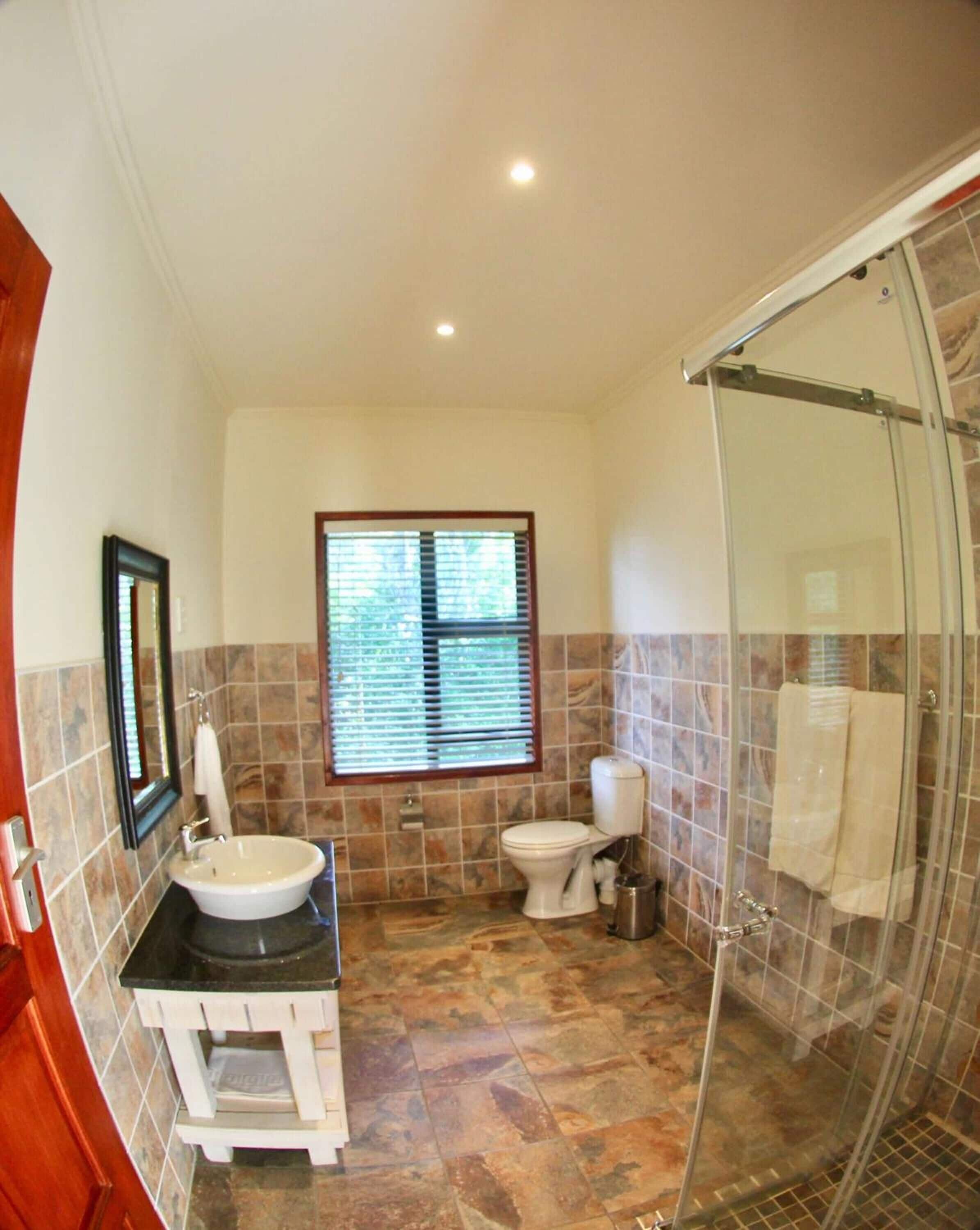 A bathroom with a sink, toilet, and shower.