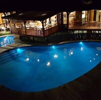 Una piscina techada, una piscina al aire libre, sombrillas