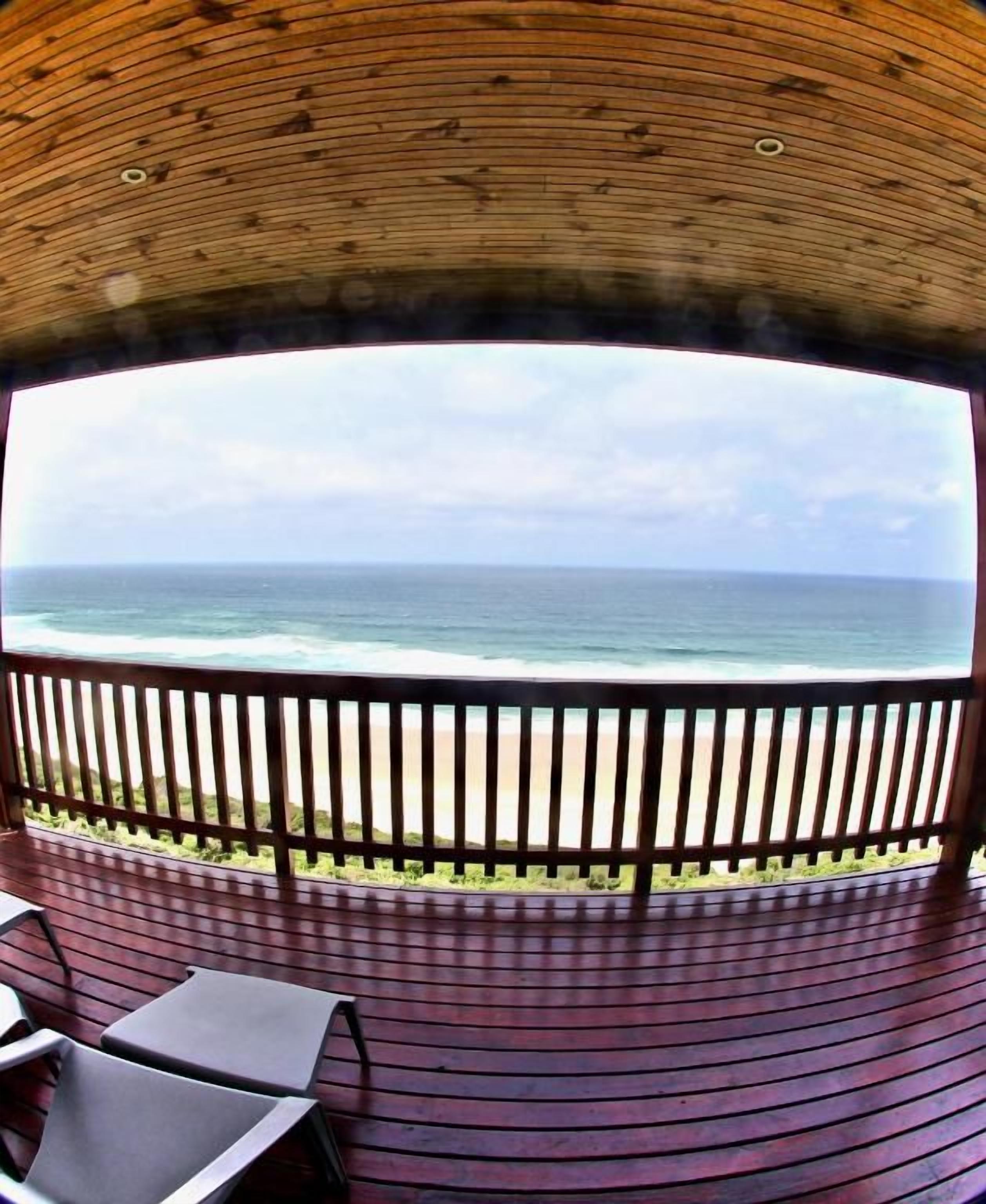 A wooden deck with a view of the ocean.