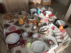 Una mesa de comedor puesta con diferentes platos, utensilios y adornos.