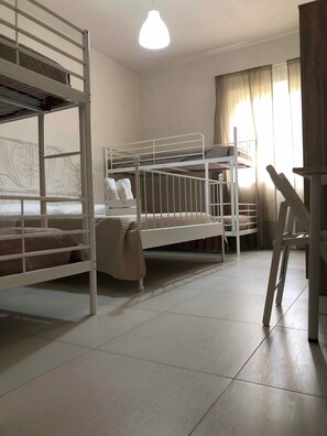 Una habitación con literas, un escritorio y una silla.