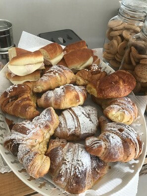 A plate of assorted pastries including croissants and sandwiches. - B&B La Via di Casa (Agrigento)