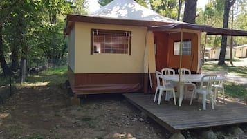 Une petite construction d’une seule pièce, dotée d’un porche et d’une table avec des chaises.