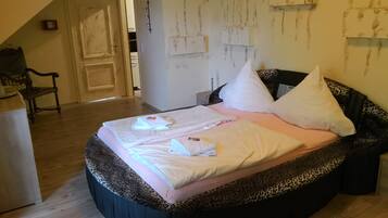 A bedroom with a bed, a chair, and a wardrobe.