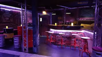 Una zona de bar con taburetes y una barra.