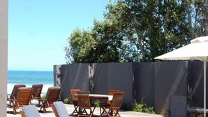 Un espace aménagé au bord de la piscine, avec des chaises longues, une table et un parasol.