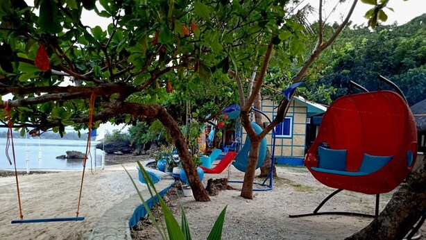 A beachside playground with swings, slides, and a red chair. - Bolo Beach Santorini (Alaminos)