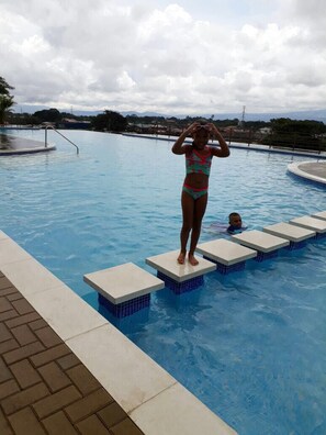 En swimmingpool med springtårn og trapper ned i vandet.