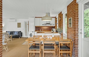 A compact living space with a dining area, kitchen, and a sofa.