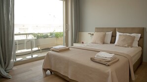 A hotel room with a large bed, a balcony with a view, and a window with curtains. - Unique AcropolisView HiEnd 2bdr (Athens)