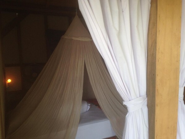 A room with a bed under a canopy.