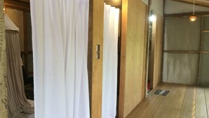 A traditional Japanese room with tatami flooring, shoji screens, and a wooden interior.