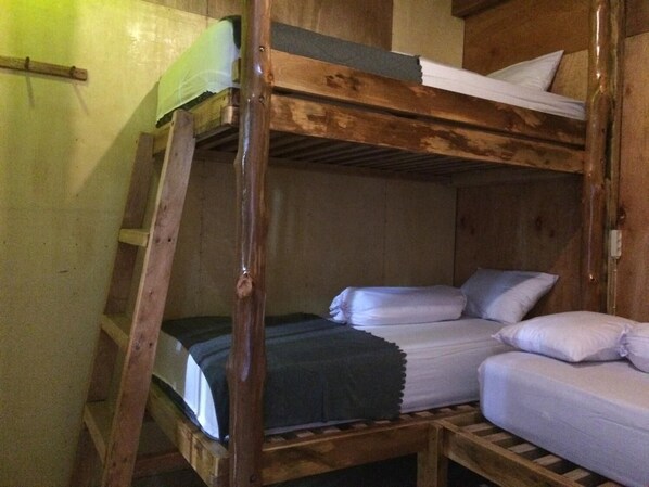 A bunk bed room with wooden walls and a ladder. - Mentawai Bagus - Hostel (Sipura Island)