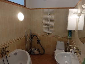 Une salle de bain avec deux lavabos, une baignoire, des toilettes et une douche équipée d’un porte-serviettes.