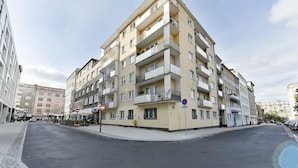 Ein mehrstöckiges Wohngebäude mit Balkonen, einem Fußgängerweg und blauem Himmel.
