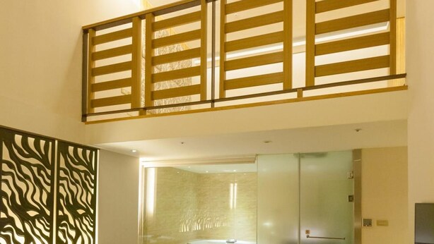 A hotel room with two beds, a glass-enclosed shower area, and a TV on the wall. - Yoai Jing Shang Hotel (Kaohsiung)