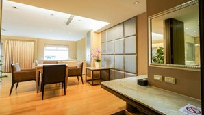 A hotel room with a dining area, a large mirror, and a potted plant. - Yoai Jing Shang Hotel (Kaohsiung)