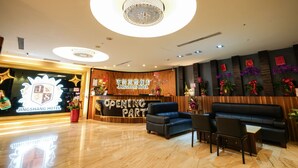 A hotel reception area with a modern design, featuring a reception desk, seating area, and decorative plants. - Yoai Jing Shang Hotel (Kaohsiung)