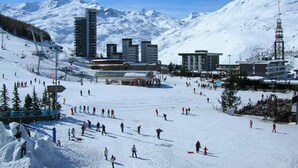 A ski resort with multiple buildings, ski lifts, and a snowy mountain backdrop. - Ski-in studio in the heart of Les Menuires, pets allowed (Les Menuires)