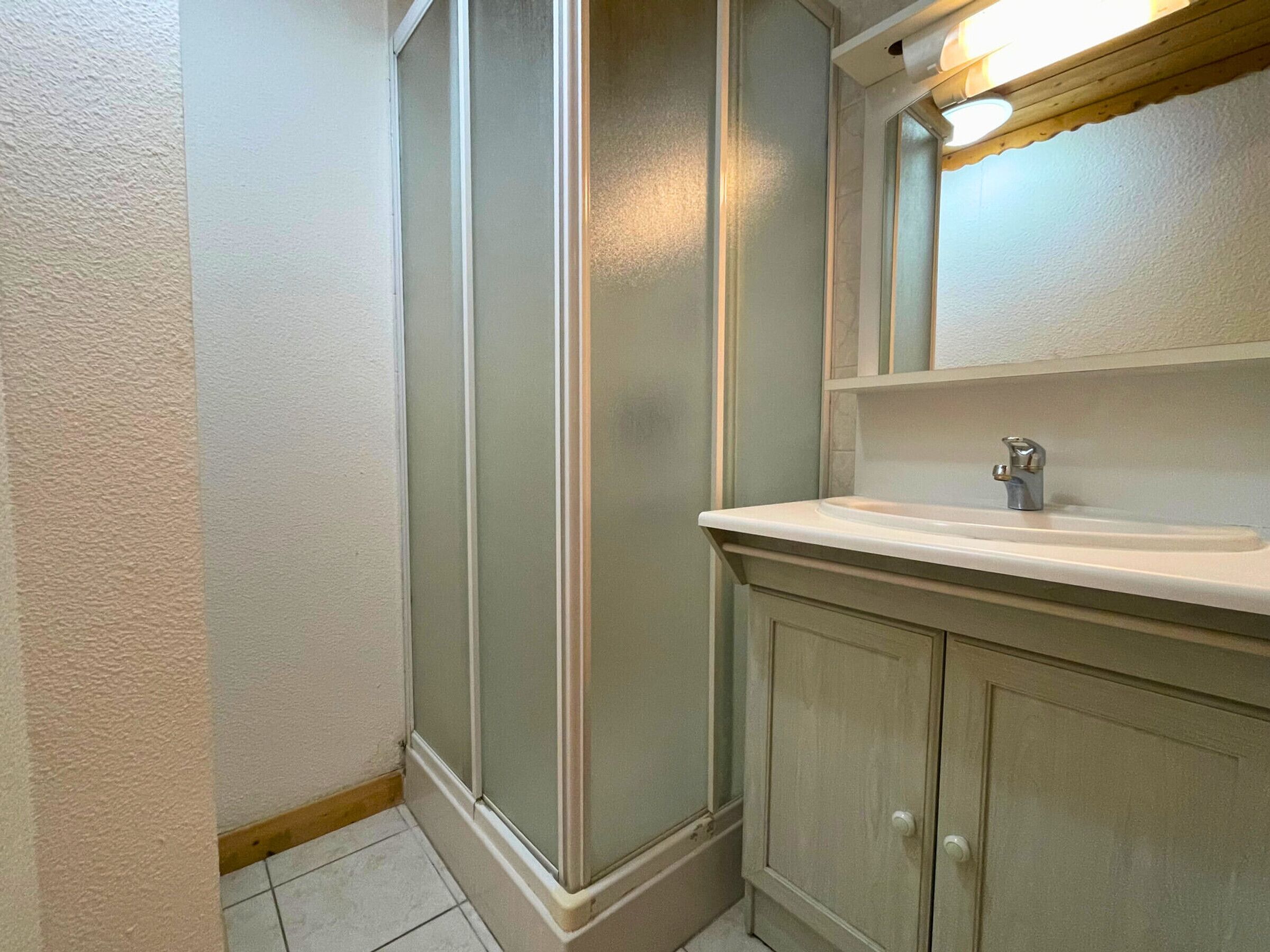 A bathroom with a shower, a sink, and a mirror.