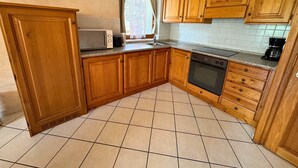 A kitchen with wooden cabinets, a microwave, a toaster, and a dishwasher.