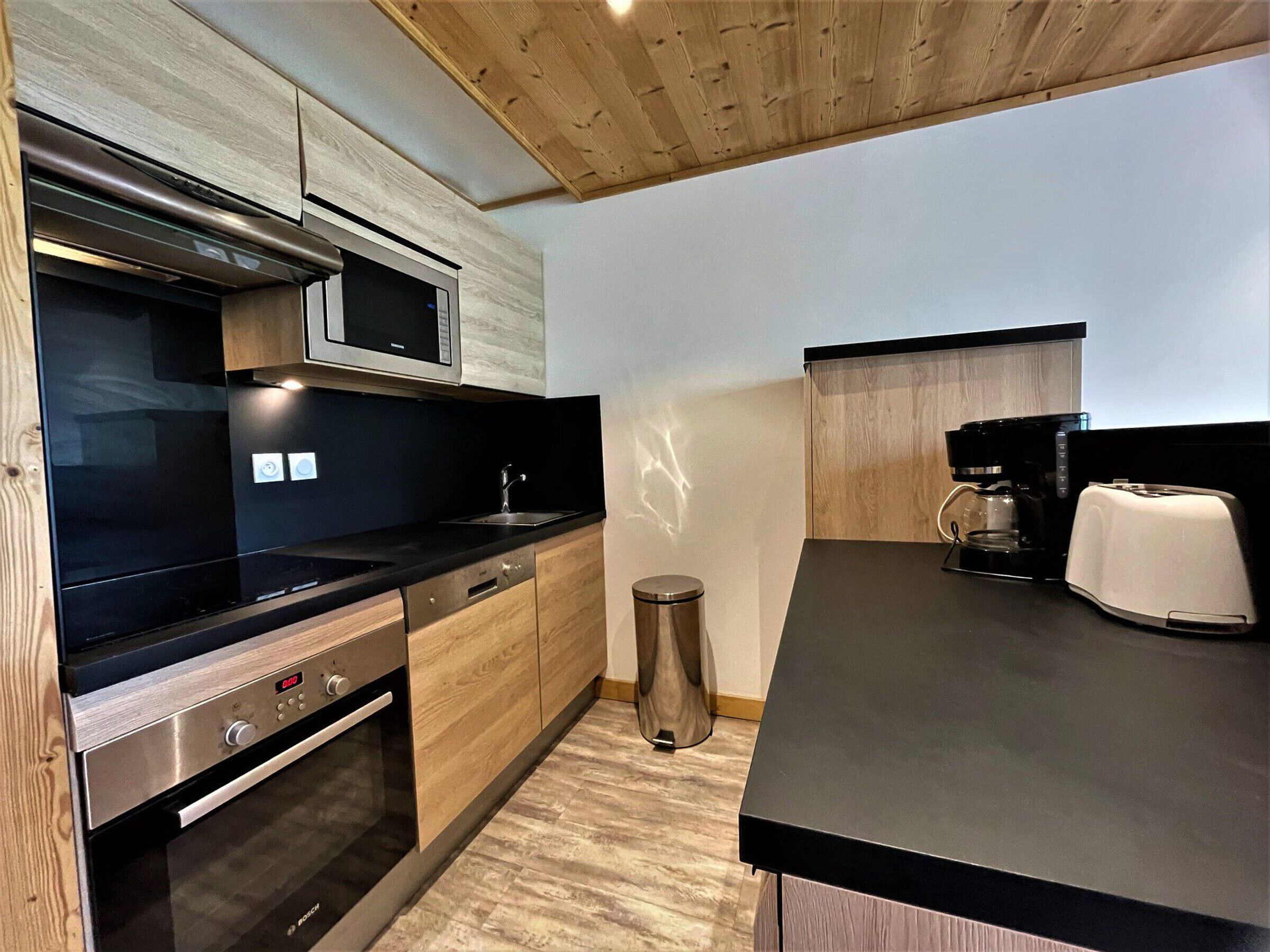 A modern kitchen with a stainless steel oven, microwave, and coffee maker.