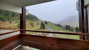 Una habitación con vistas a un paisaje rural, que incluye una carretera y casas.
