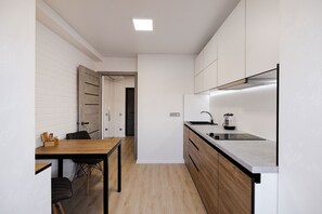 A compact kitchen with a wooden table, a sink, and cabinets.