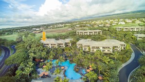 A resort with a large pool, multiple buildings, and lush greenery.
