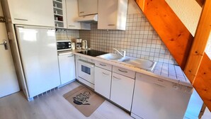 A compact kitchen with white cabinets, a microwave, a coffee maker, and a Bosch dishwasher. - Economical apartment with mezzanine for 6 people in Les Menuires (Les Menuires)