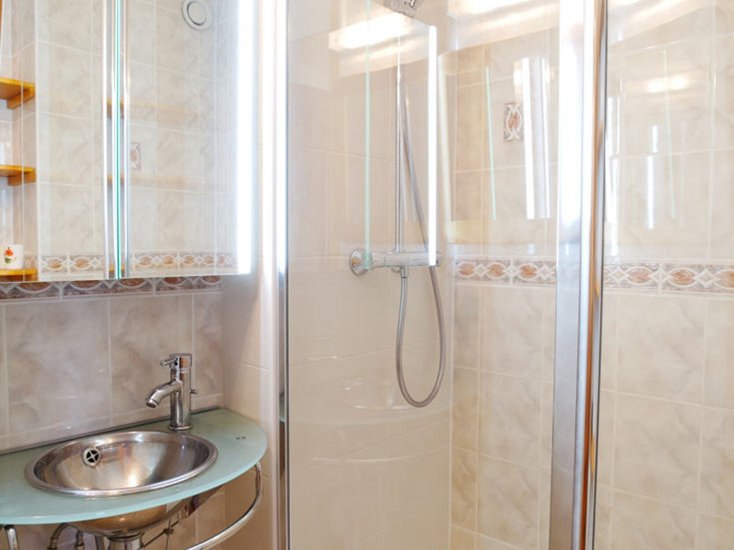 Une salle de bain avec un lavabo, un miroir et une douche.