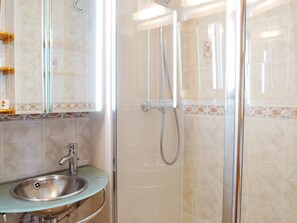 Un baño con lavamanos, espejo y ducha.