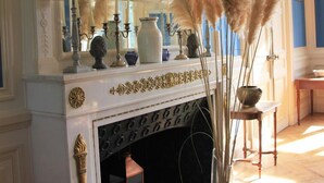 A room with a fireplace, decorative candelabras, and pampas grass. - Château du Gerfaut (Azay-le-Rideau)
