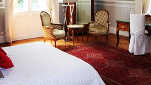 A room with a bed, two chairs, a desk, a mirror, and a red carpet. - Château du Gerfaut (Azay-le-Rideau)