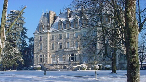 A large, historic building with a symmetrical facade, multiple chimneys, and a central entrance with steps leading up to it. - Château du Gerfaut (Azay-le-Rideau)