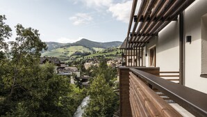 Een balkon met uitzicht op een rivier en een stad in de vallei.