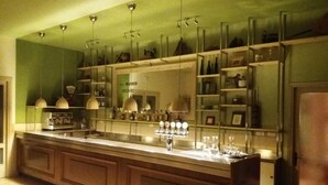 A kitchen with a long counter, hanging pendant lights, and a mirrored backsplash. - Damarco Alloggio Turistico Locanda (Schio)